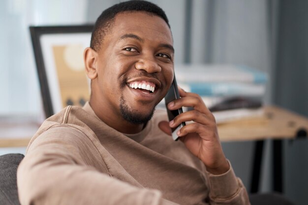 Llamada telefónica con teléfono inteligente hombre negro sonrisa y conversación telefónica hombre de negocios en la oficina y comunicación y tecnología de contacto Oficina moderna hablando y red 5g con móvil feliz de guardia