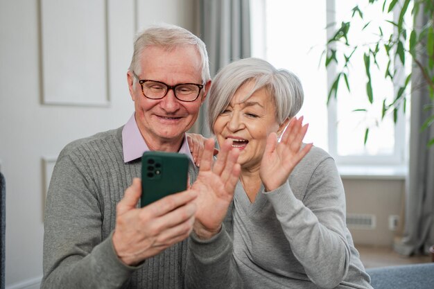 Foto llamada de video feliz pareja de ancianos mujer hombre con teléfono inteligente teniendo llamada de video madura abuela vieja