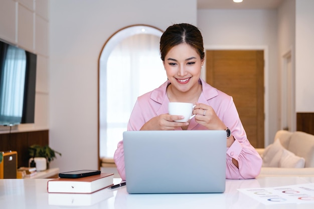 Llamada de videoconferencia remota Internet de negocios teletrabajo Mujer de negocios bebiendo café por computadora portátil