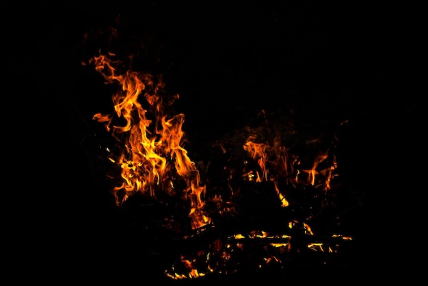 Llamas de fuego sobre fondo negro de arte abstracto Quemando chispas al rojo vivo se elevan de un gran incendio