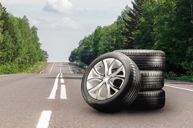 Llantas de verano y llantas de aleación colocadas en una carretera de asfalto temporada de cambio de llantas auto comercio espacio de copia auto ...