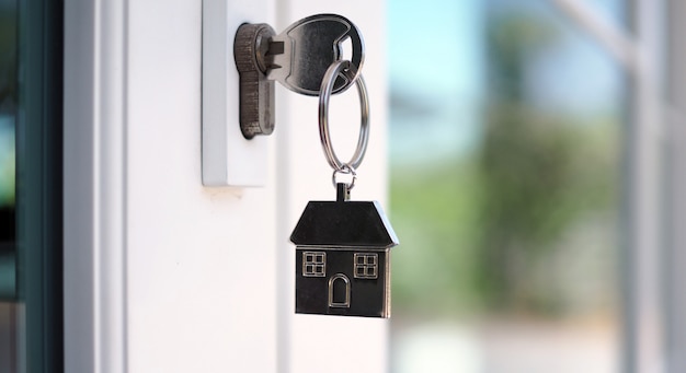La llave de la casa para desbloquear una casa nueva está conectada a la puerta.