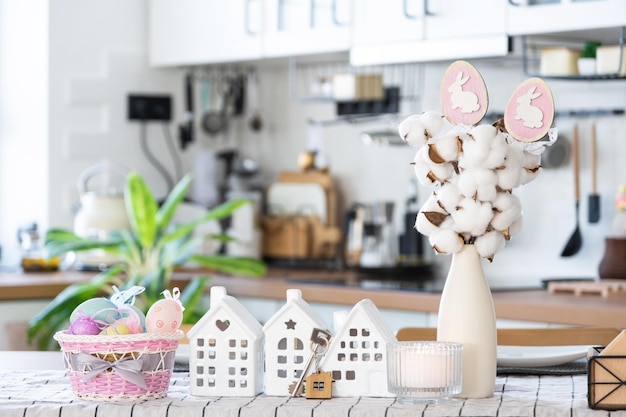 Llave de casa de hogar acogedor con decoración de Pascua con conejo y huevos en la mesa de la cocina Proyecto de diseño de construcción que se traslada a una casa nueva seguro hipotecario alquiler y compra de bienes raíces