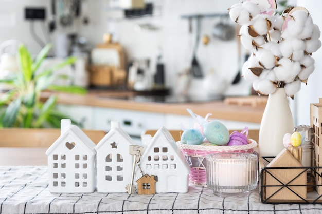 Llave de casa de hogar acogedor con decoración de Pascua con conejo y huevos en la mesa de la cocina Proyecto de diseño de construcción que se traslada a una casa nueva seguro hipotecario alquiler y compra de bienes raíces