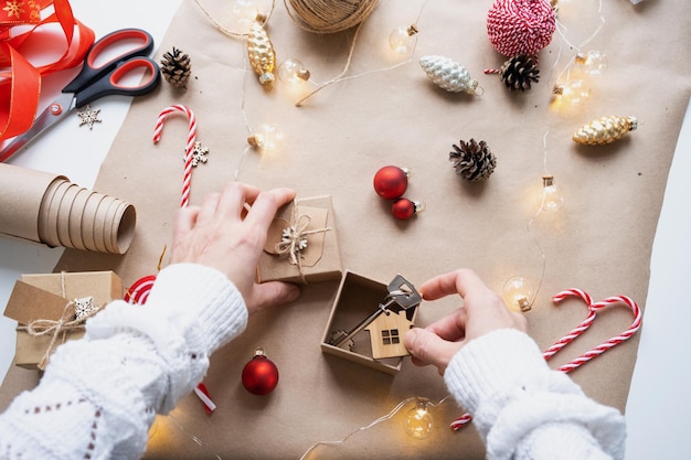 Llave de la casa con llavero en una casa acogedora en caja de regalo con empaque de decoración navideña Paquete presente para el proyecto de construcción de Navidad de Año Nuevo que se muda a una nueva casa hipoteca alquiler compra bienes raíces