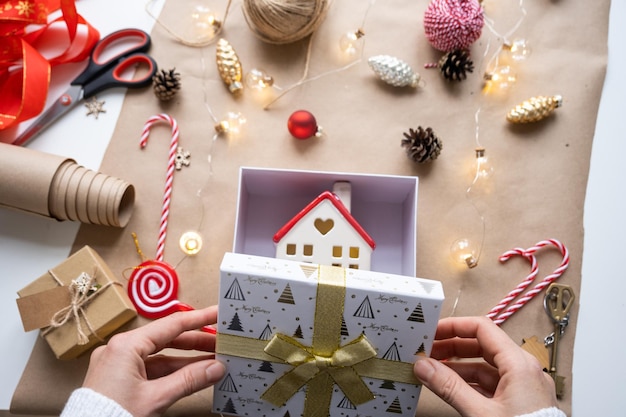 Llave de la casa con llavero en una casa acogedora en caja de regalo con empaque de decoración navideña Paquete presente para el proyecto de construcción de Navidad de Año Nuevo que se muda a una nueva casa hipoteca alquiler compra bienes raíces