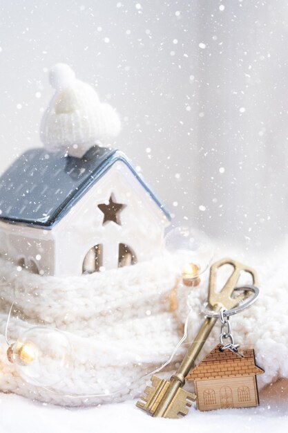 Llave de la casa con un llavero en una casa acogedora con una decoración navideña Un regalo para el proyecto de diseño del edificio de Navidad de Año Nuevo mudarse a una nueva casa hipoteca alquiler y compra de bienes raíces