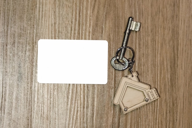 Foto llave de la casa con maqueta de tarjeta de crédito en mesa de madera