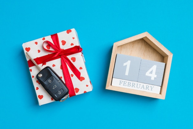 Llave del coche en una caja de regalo con corazones rojos y calendario festivo