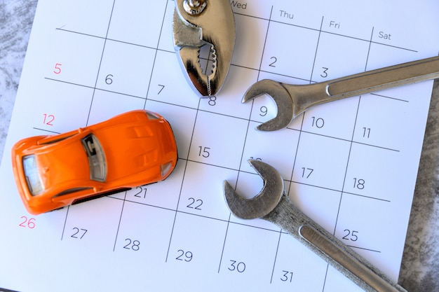 Llave y coche en el calendario con números. concepto de reparación