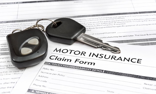 Llave del coche en el formulario de reclamación de seguros de automóviles