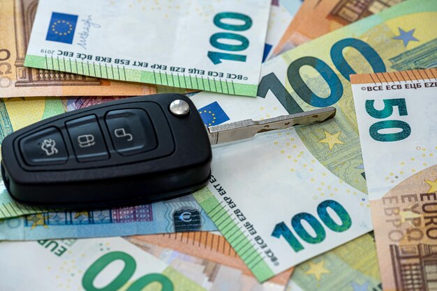 La llave del coche negro se encuentra en el dinero del euro como fondo de venta de seguros de automóviles pr alquiler