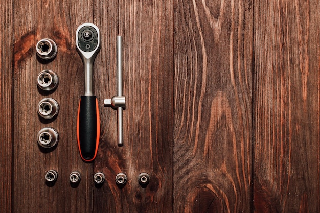 Llave de herramientas y tuercas sobre fondo de madera