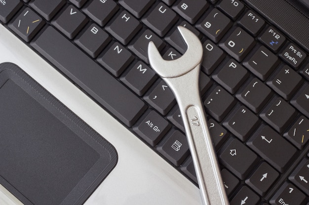 Foto llave inglesa en el teclado del portátil, el concepto de reparación de maquinaria.