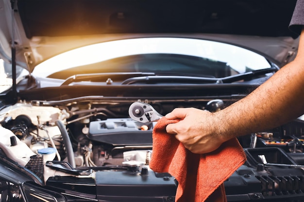 Llave de mano mecánica automática y paño rojo para reparar el coche con fondo de motor de coche