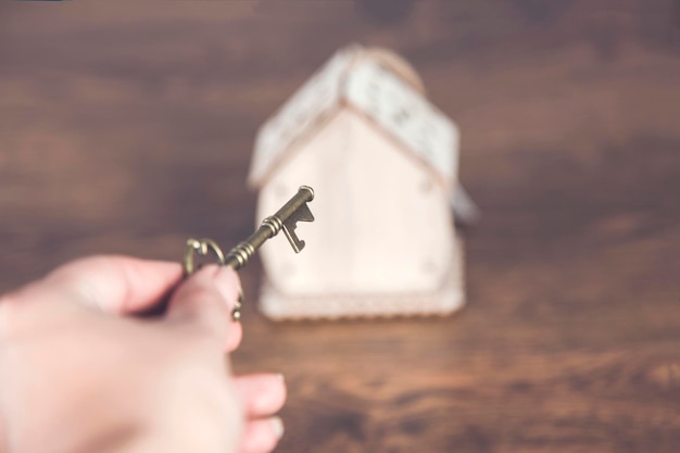 Llave de mano de mujer y modelo de casa