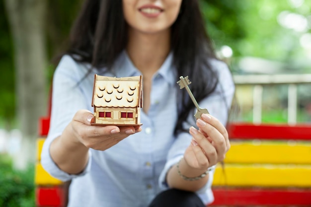 Llave y modelo de casa de mano de mujer