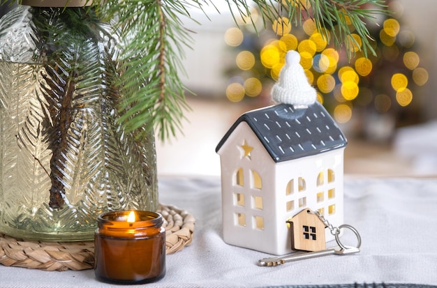 Llave y pequeña casa de un tamaño pequeño en un hogar acogedor con decoración navideña en la mesa de la cocina festiva