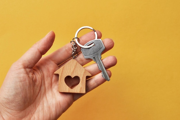 Foto llaves con una ardilla en forma de casa en la mano de una persona.