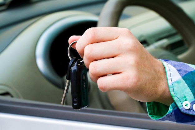 Llaves de auto en mano mientras conduce un auto