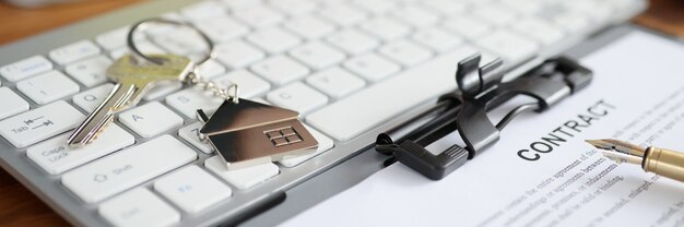 Foto llaves de la casa y documento con contrato en primer plano del teclado. concepto de seguro de hogar