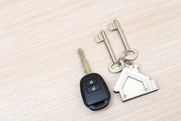 Llaves del coche y de la casa en la tabla. Concepto de éxito.