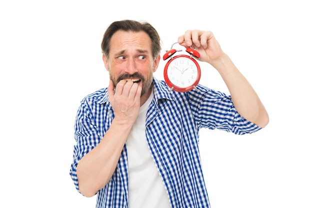 Llegar tarde. El hombre mayor estresado se preocupa por estar atrasado. Hombre barbudo con reloj y estrés en la cara. Cronometrador maduro con reloj. Hombre maduro con despertador. Horario de programación. Sentir estrés.