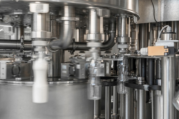 Llenado de leche en botellas de plástico en el equipo de fábrica en la planta lechera