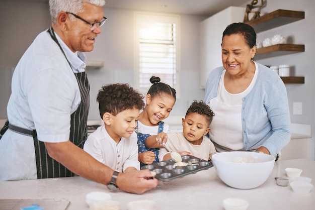 Llenar las bandejas hasta la mitad de la manera correcta Fotografía de una pareja madura horneando con sus nietos en casa