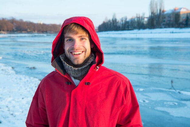 Hombre barbudo feliz con gafas de sol en un clima soleado y nevado concepto  de pasar tiempo activo caminando después de una ventisca de nieve el tipo  sonriendo y usando una chaqueta de invierno