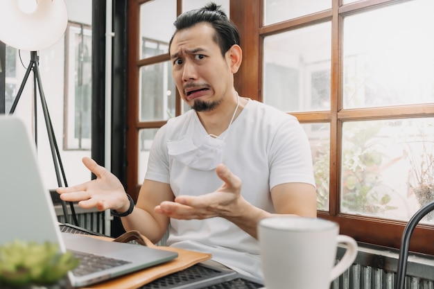 Llorando y sorprendido rostro gracioso del hombre decepcionar su trabajo en su computadora portátil