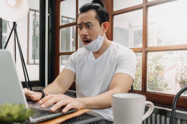 Llorando y sorprendido rostro gracioso del hombre decepcionar su trabajo en su computadora portátil