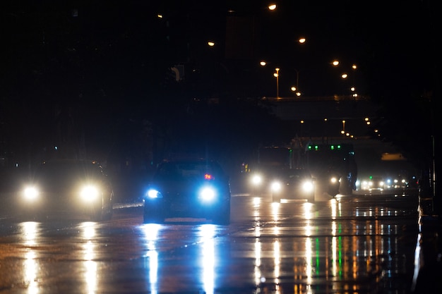 Llueve sobre la ciudad en calles con coches y motos.