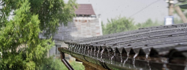 La lluvia fluye desde un techo hacia abajo