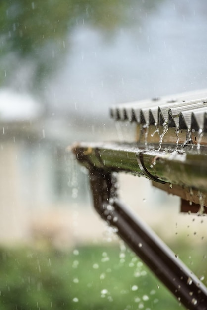 La lluvia fluye desde un techo hacia abajo