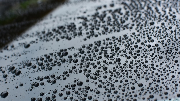 Foto lluvia gotas de lluvia en el suelo de la pintura del coche