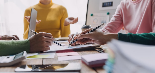 Lluvia de ideas Colaboración y análisis de asociación exitoso por jóvenes empresarios asiáticos que trabajan en un espacio de trabajo de oficina