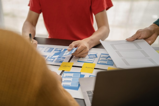 Lluvia de ideas del diseñador de la interfaz de usuario sobre el diseño de la estructura alámbrica de la interfaz de la aplicación móvil con el resumen del cliente y el código de color en la oficina