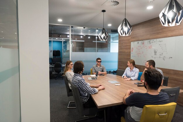 Foto lluvia de ideas del equipo de negocios de inicio sobre reuniones trabajando en computadoras portátiles y tabletas