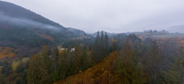 Lluvioso clima gris y niebla en el valle de la montaña de los Cárpatos en Ucrania en la pequeña aldea aérea panorámica drone shot