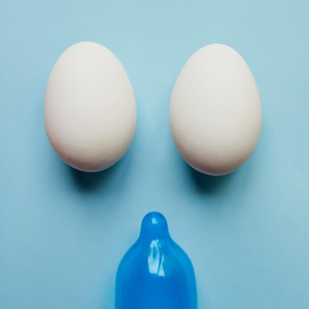 Lo siento, chicos, no sucederá hoy Foto de estudio de un condón azul y dos huevos colocados contra un fondo azul