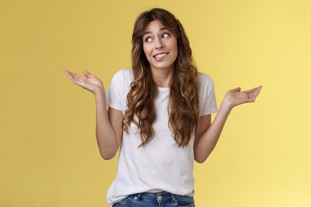 Lo siento, no puedo ayudarte. Tonto torpe linda mujer bonita pelo largo y rizado encogiéndose de hombros mirando hacia otro lado avergonzado decir oops disculparse encogiéndose de hombros inconsciente desorientado indiferente reacio a la situación del trato