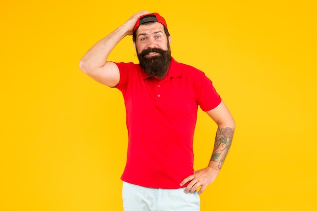 Lo siento Olvidó su pedido Contratación de trabajador de tienda Cajero hipster Servicio de entrega Hombre barbudo tatuado gorra hipster cajero uniforme fondo amarillo Concepto de cajero Carrera de cajero vendedor