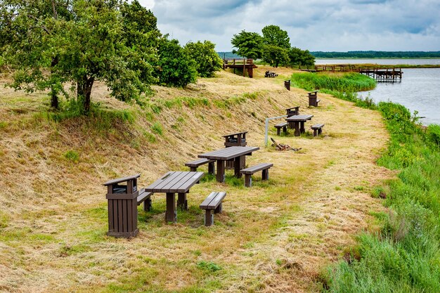 Local de piquenique com bancos e mesas para churrasco à beira do lago Zirgu Island Liepaja Letônia