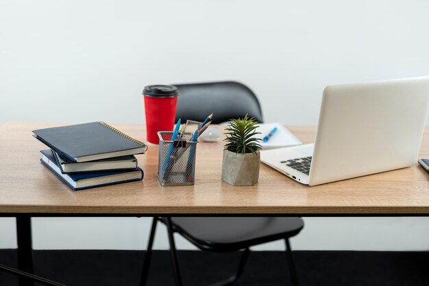 Local de trabalho com bloco de notas, caneta, calculadora, laptop, café e teclado