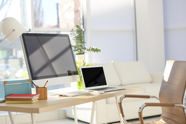 Local de trabalho com computador e laptop na mesa na sala moderna