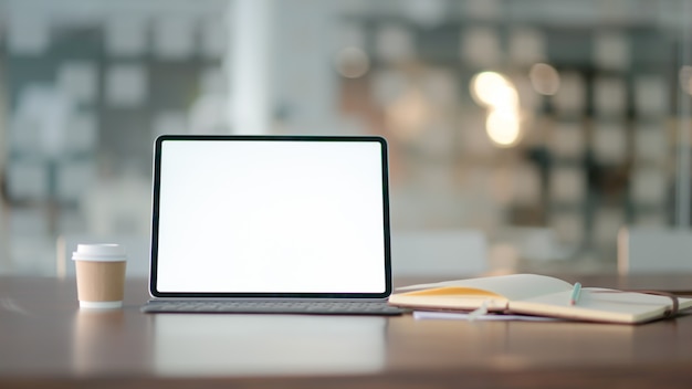 Local de trabalho com computador portátil, material de escritório e café.