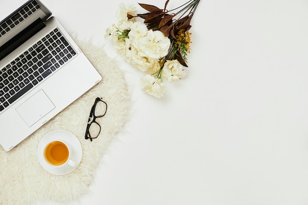 Foto local de trabalho com laptop e flores