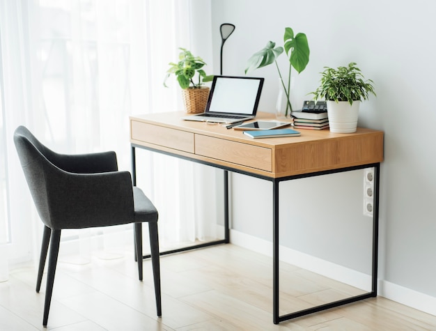 Local de trabalho de escritório com laptop na mesa de madeira