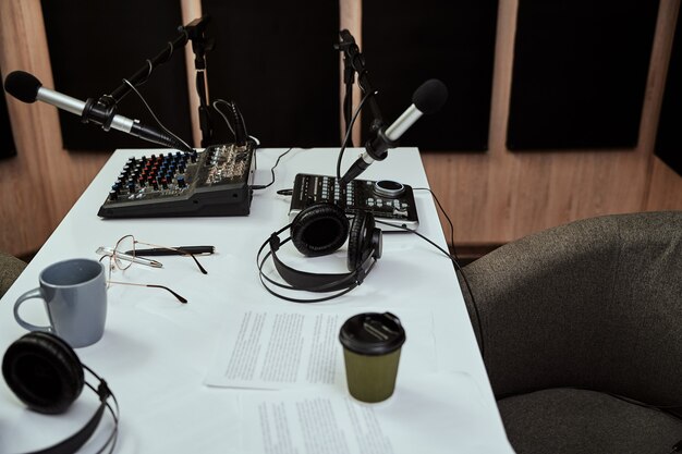 Foto local de trabalho do locutor de rádio perto de microfones, fones de ouvido, mixagem de roteiro no